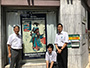 東日本橋の入口にある大丸文房具店に飾られた浮世絵のれんの前で、製作者のミカ製版の橋本常務、神田デザイナー、高橋さん