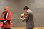 手締め前の奉納ほら貝の演奏をする小林宝林堂の国分社長と聞き入る日本橋めぐりの会の川崎代表